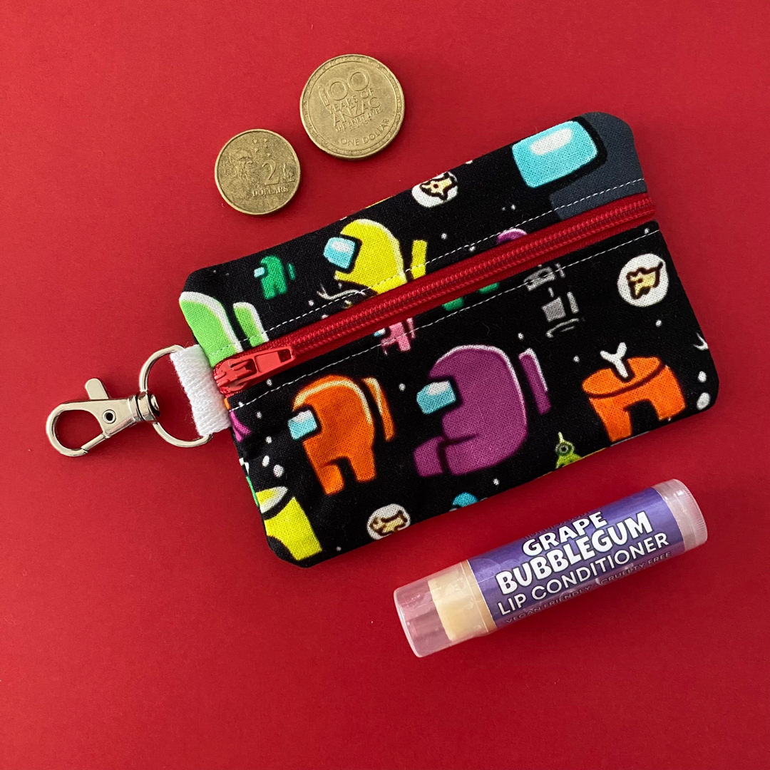 A small clip coin purse perfect for coins and small essentials featuring Among Us characters on black fabric.
