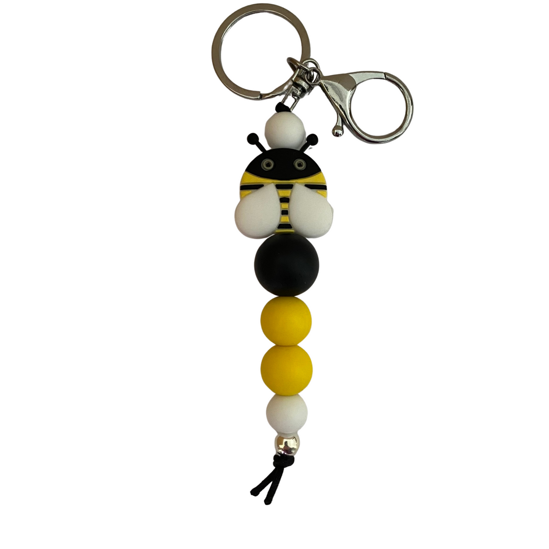 An 18cm keyring with a bee silicone bead and other coloured round silicone beads.