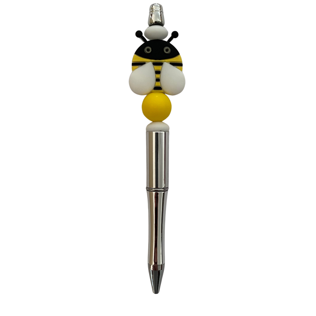 A black ink refillable pen with a bee silicone bead on top.