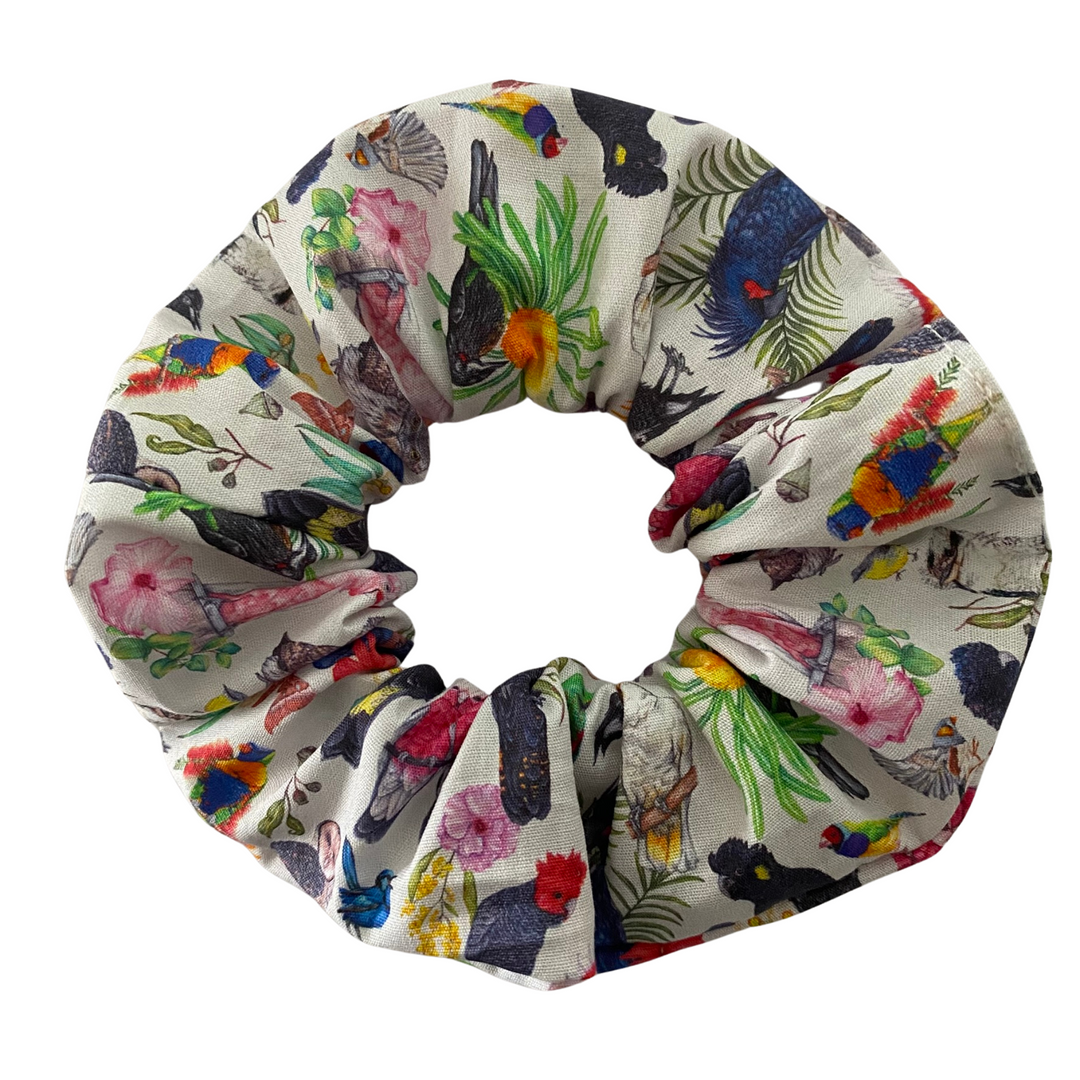 A white fabric scrunchie with illustrations of Birds found in Australia. Magpies, Kookaburras, Rainbow Lorrikeets and so many other birds.