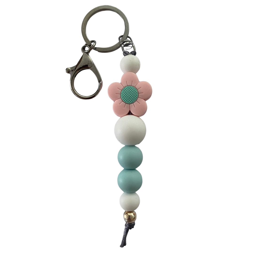 Bright Blooms Pink Flower silicone keyring with white and light blue beads, a 10mm aluminum bead, and durable nylon cord. Perfect for keys or bags.