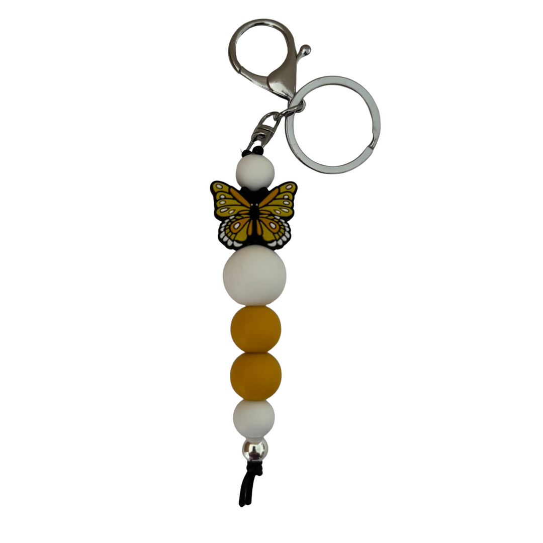 An 18cm keyring featuring a yellow butterfly silicone bead and white and yellow round silicone beads.