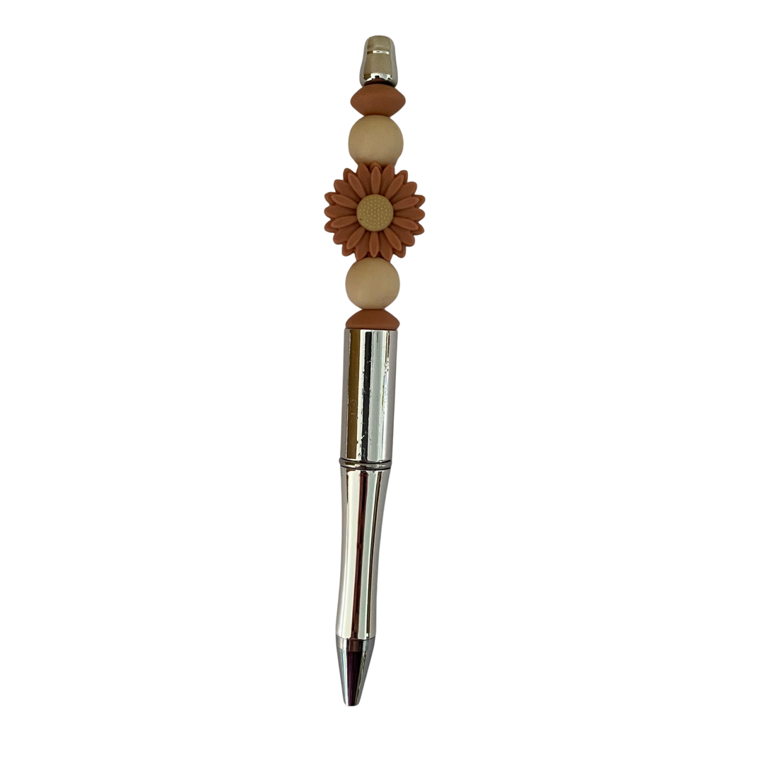 Decorative daisy clay pen with beads on a white background.