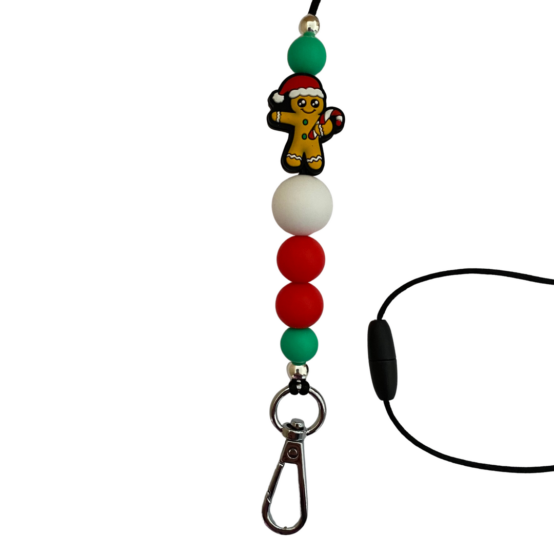 A 60cm lanyard fitted with a safety break away clasp featuring a gingerbread man holding a candy cane bead and other coloured round silicone beads.