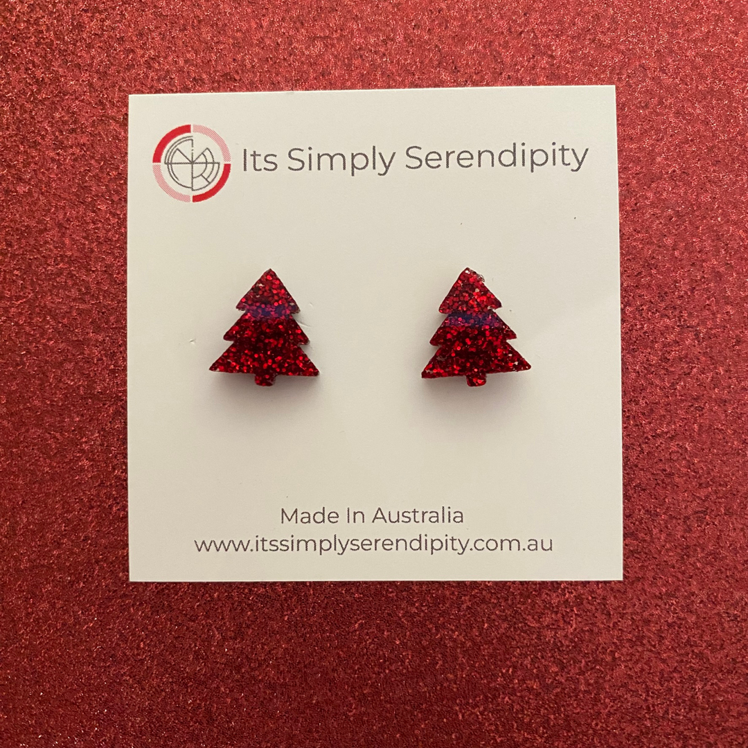 Red glittery tree-shaped earrings on a 'Its Simply Serendipity' card against a red background.