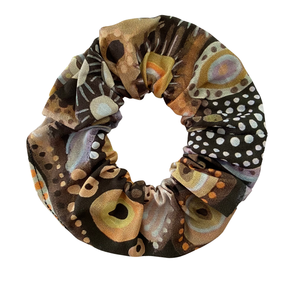 A scrunchie hair tie handmade with fabric by Aboriginal Artist Holly Sanders called Medicine Country.
