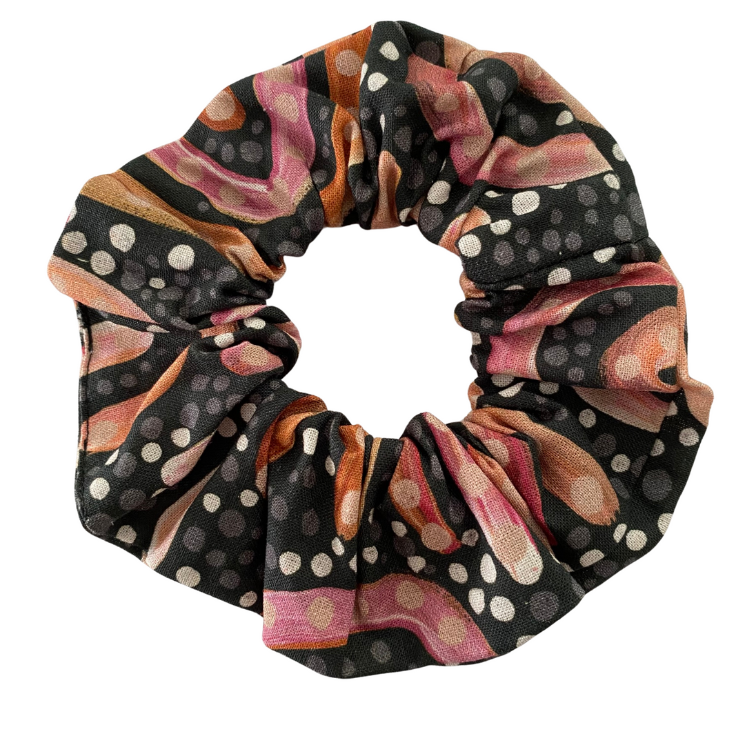 A scrunchie hair tie handmade with fabric by Aboriginal Artist Holly Sanders called Sandhills.