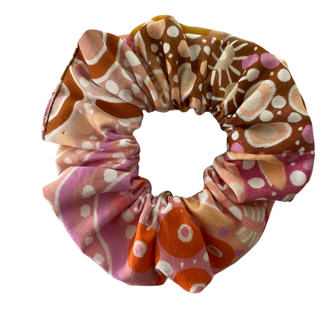 A scrunchie hair tie handmade with fabric by Aboriginal Artist Holly Sanders called Women on Country.