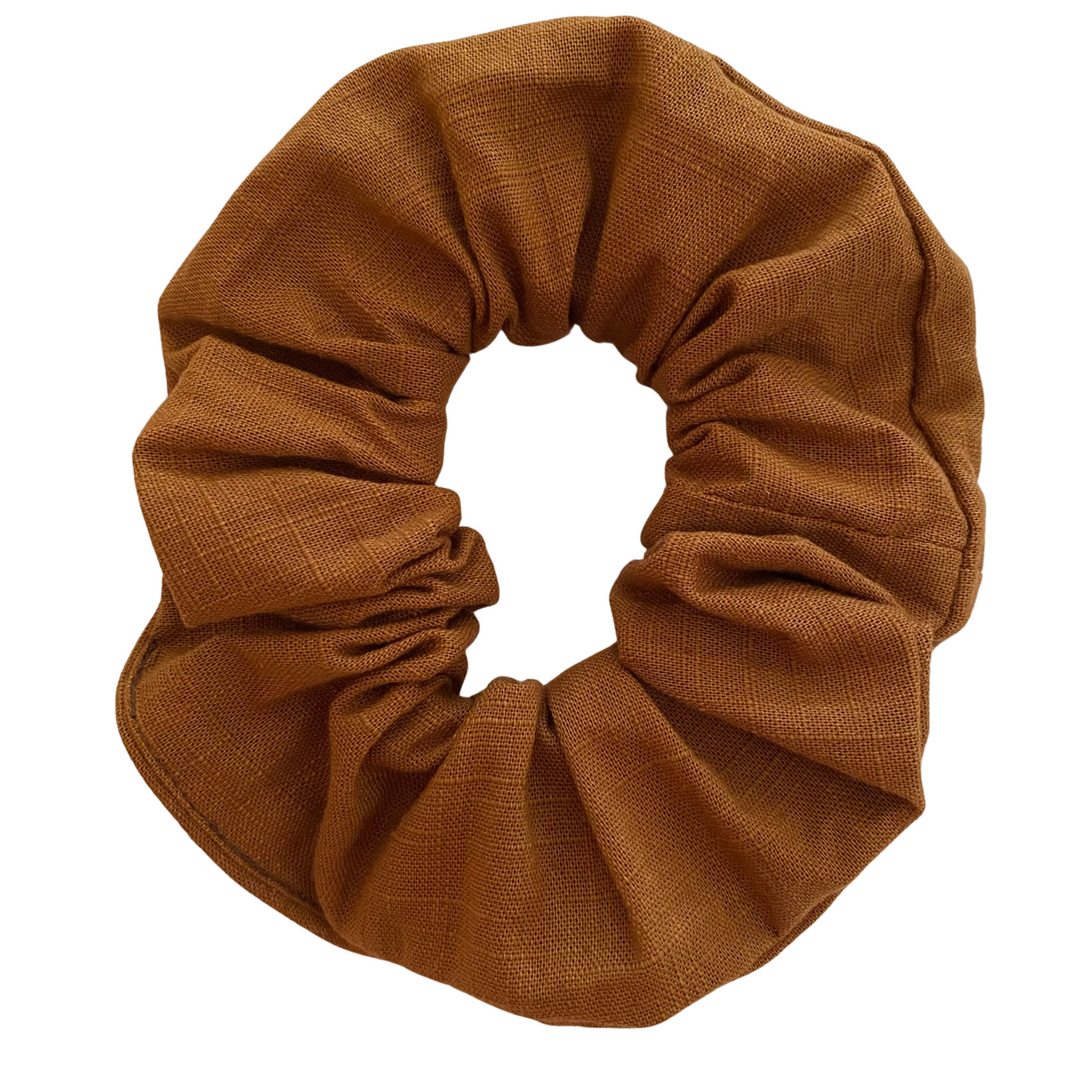 A linen scrunchie in mustard seeds colour