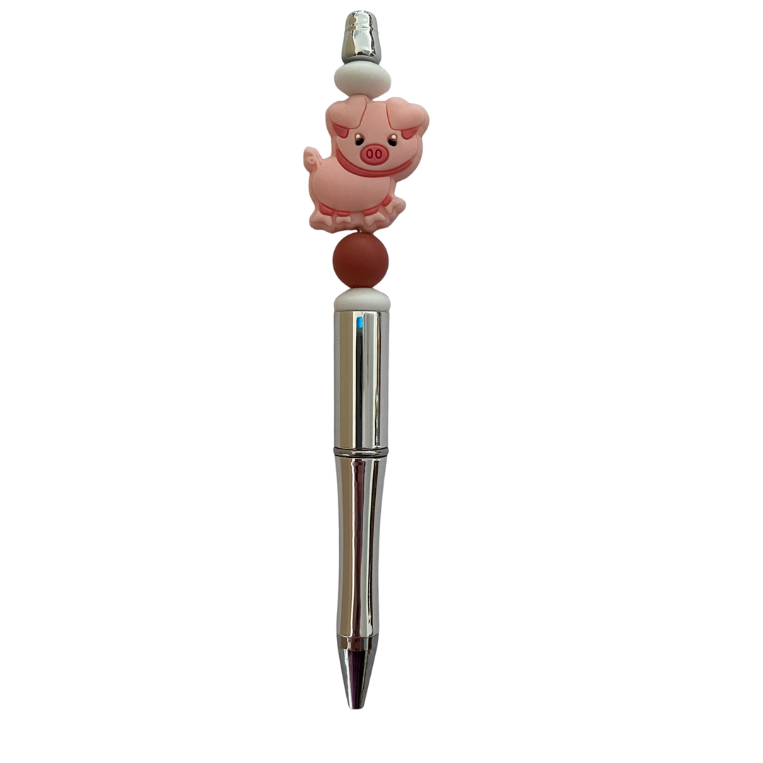 Pen with a pig silicone bead on top on a white background.