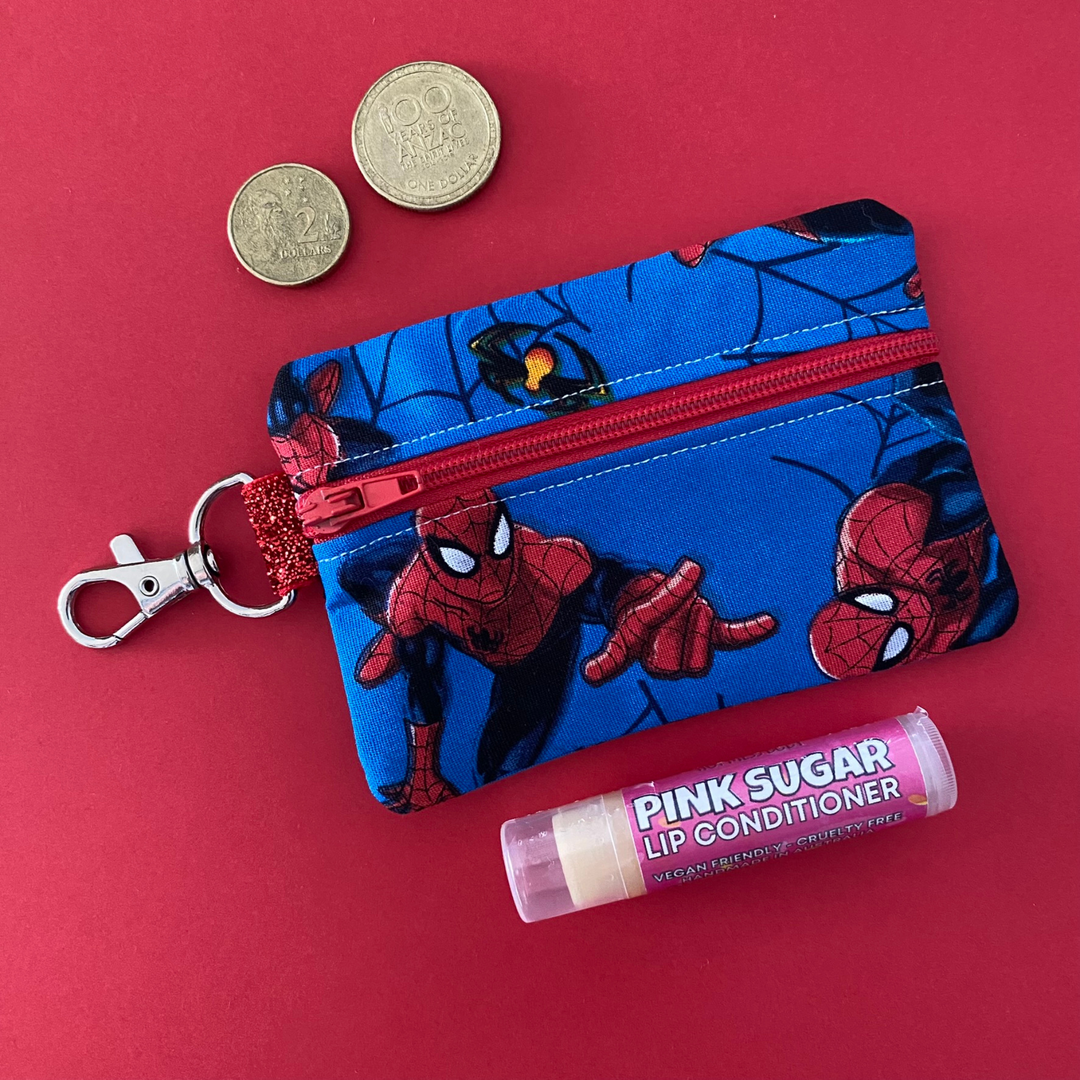 A small clip coin purse perfect for coins and small essentials featuring Spiderman on blue fabric.
