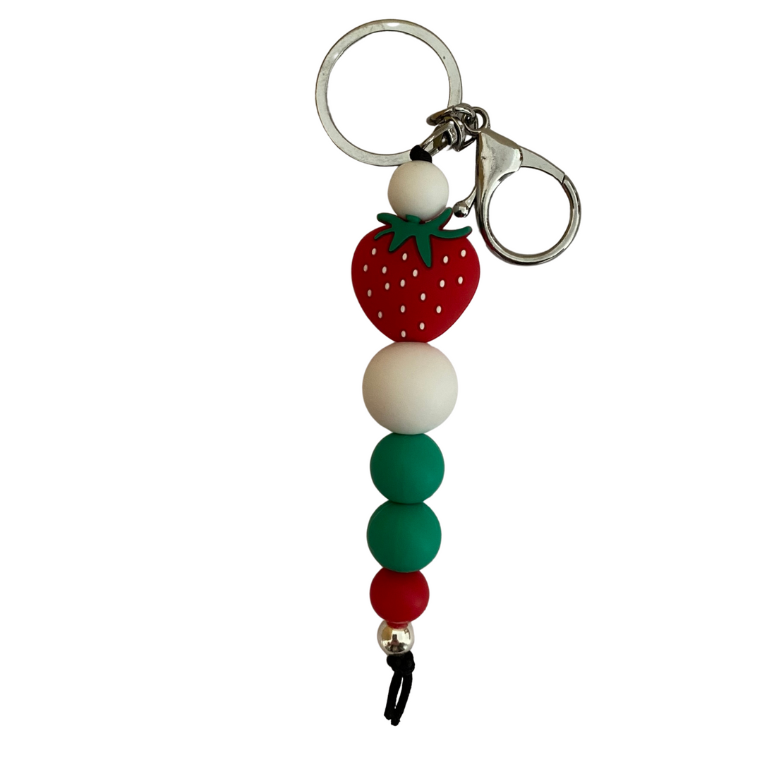 A keyring with a strawberry silicone bead and other round coloured silicone beads.