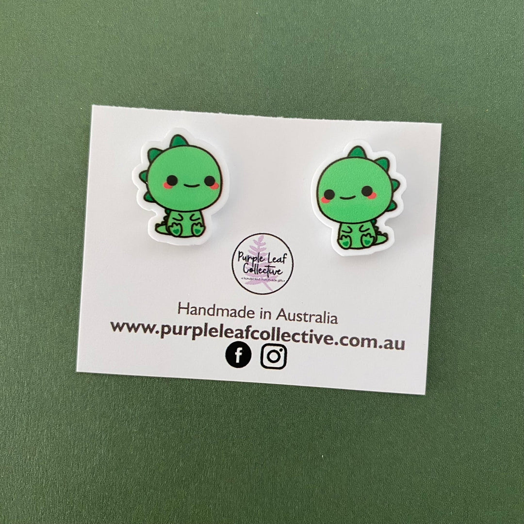 Green T-Rex Dinosaur novelty stud earrings. Hypoallergic Surgical Steel Posts. Printed Acrylic. Approx 15mm.