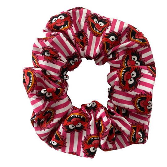 Scrunchie with pink and white stripes and red animal puppet character pattern on a white background.