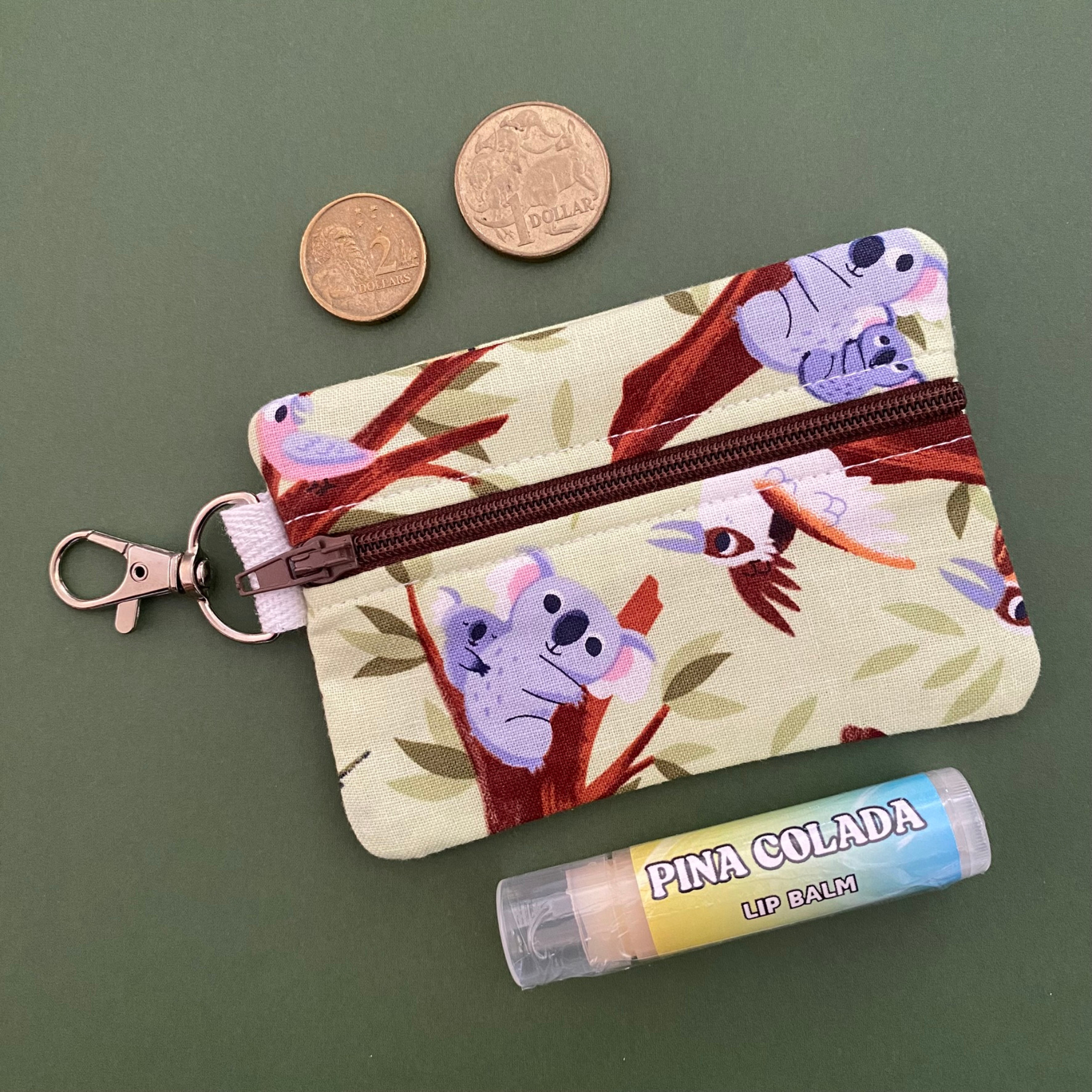 A clip coin purse featuring Aussie  treetop favourites—including Koalas, Cockatoos, Galahs, Ringtail Possums, Kookaburras, and Rainbow Lorikeets.