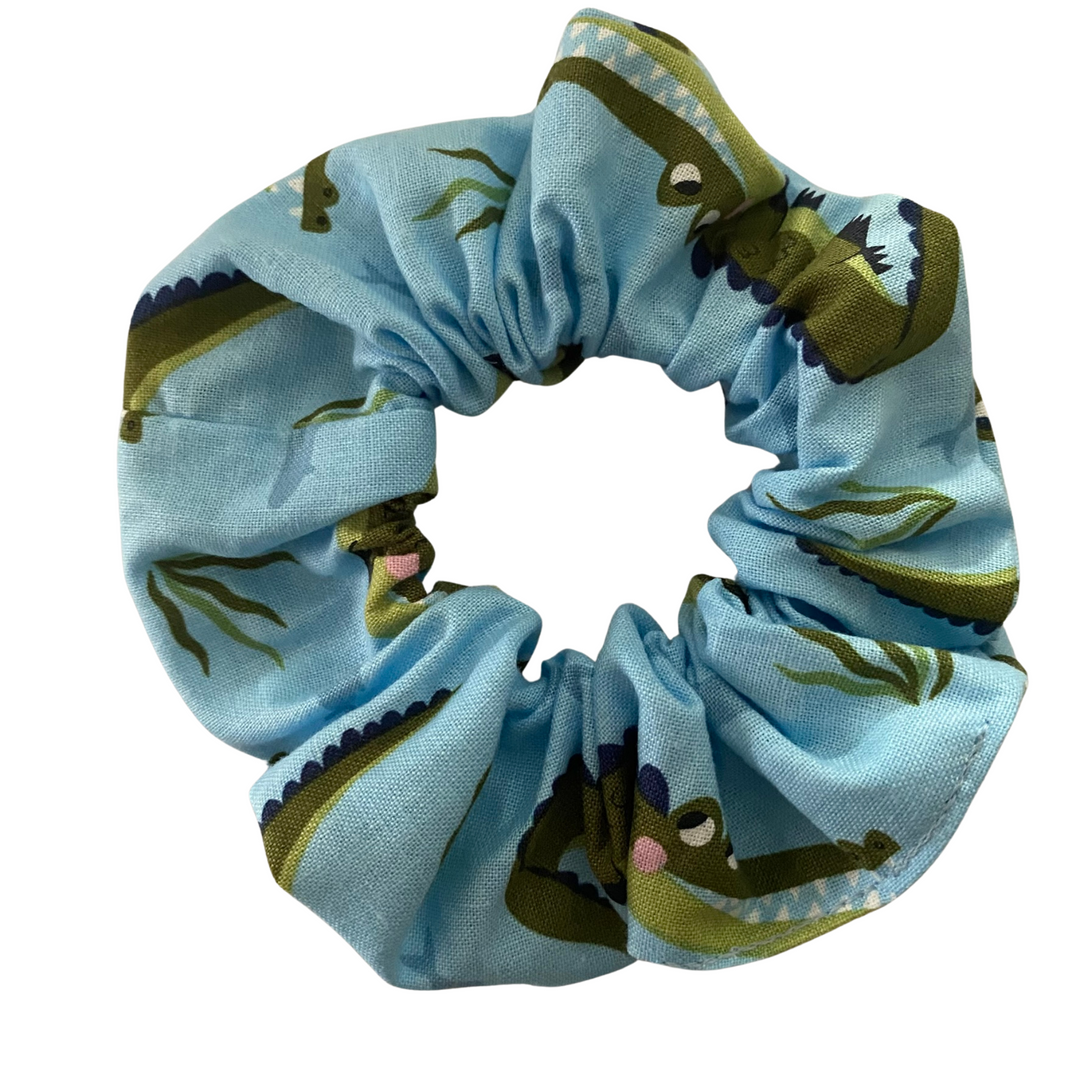 A light blue coloured fabric featuring images of swimming crocodiles.