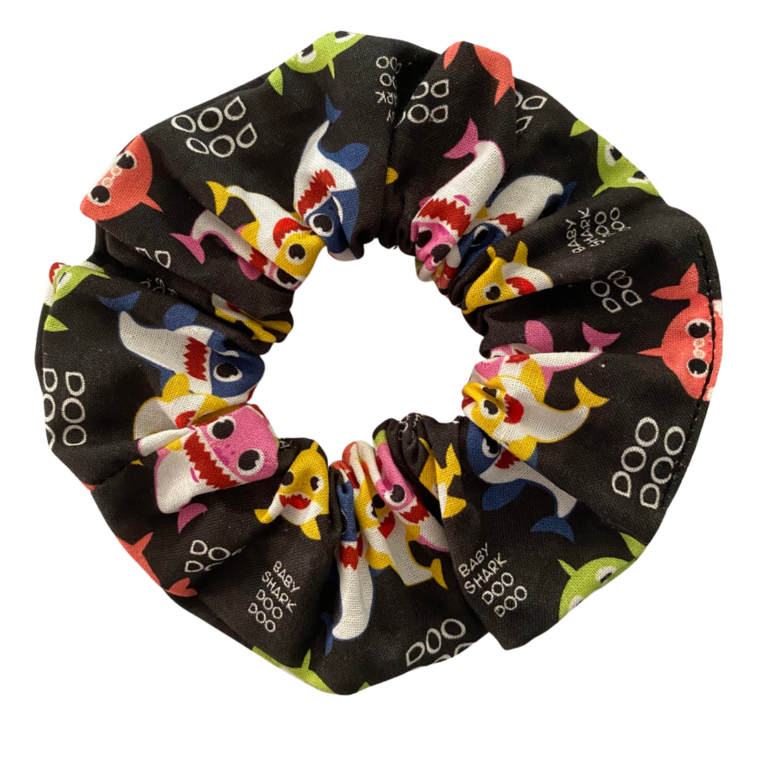 Black fabric scrunchie with colourful images of baby shark family and Doo Doo wording.