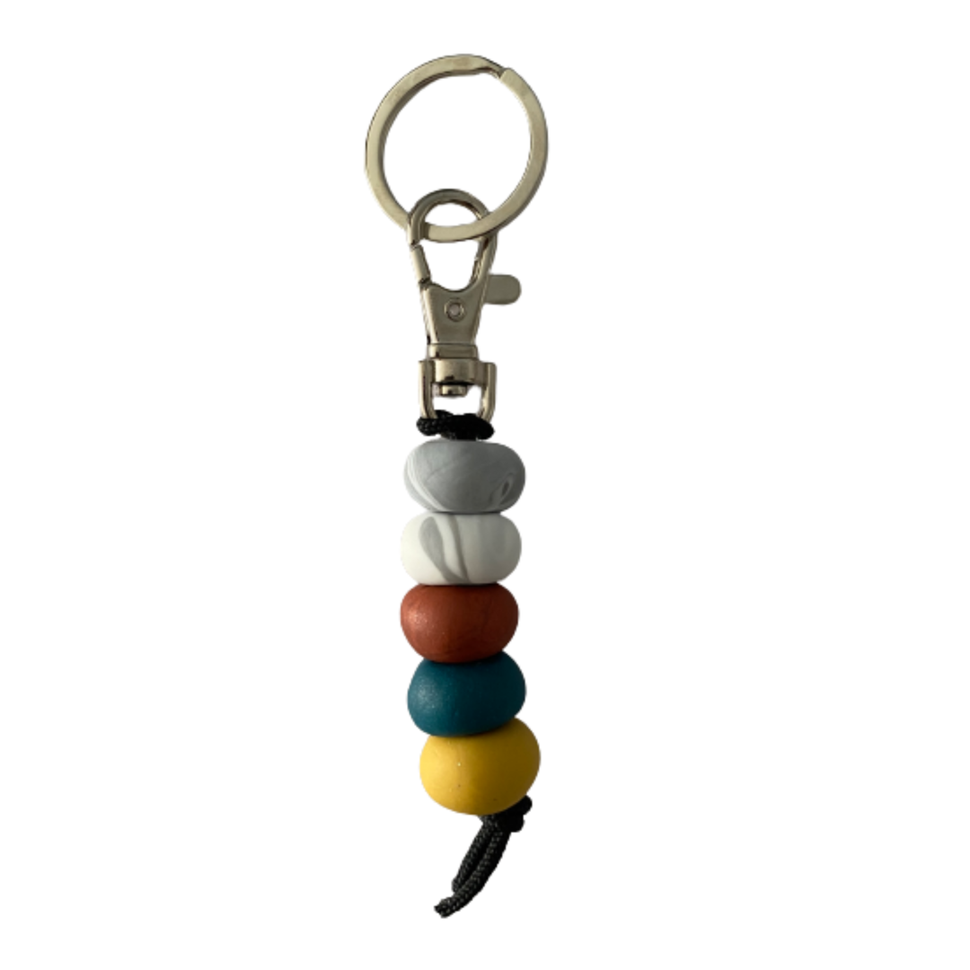 Handmade polymer clay keyring featuring five hand-rolled beads in teal, mustard, brown with two marble effect designs, attached to a silver clasp.