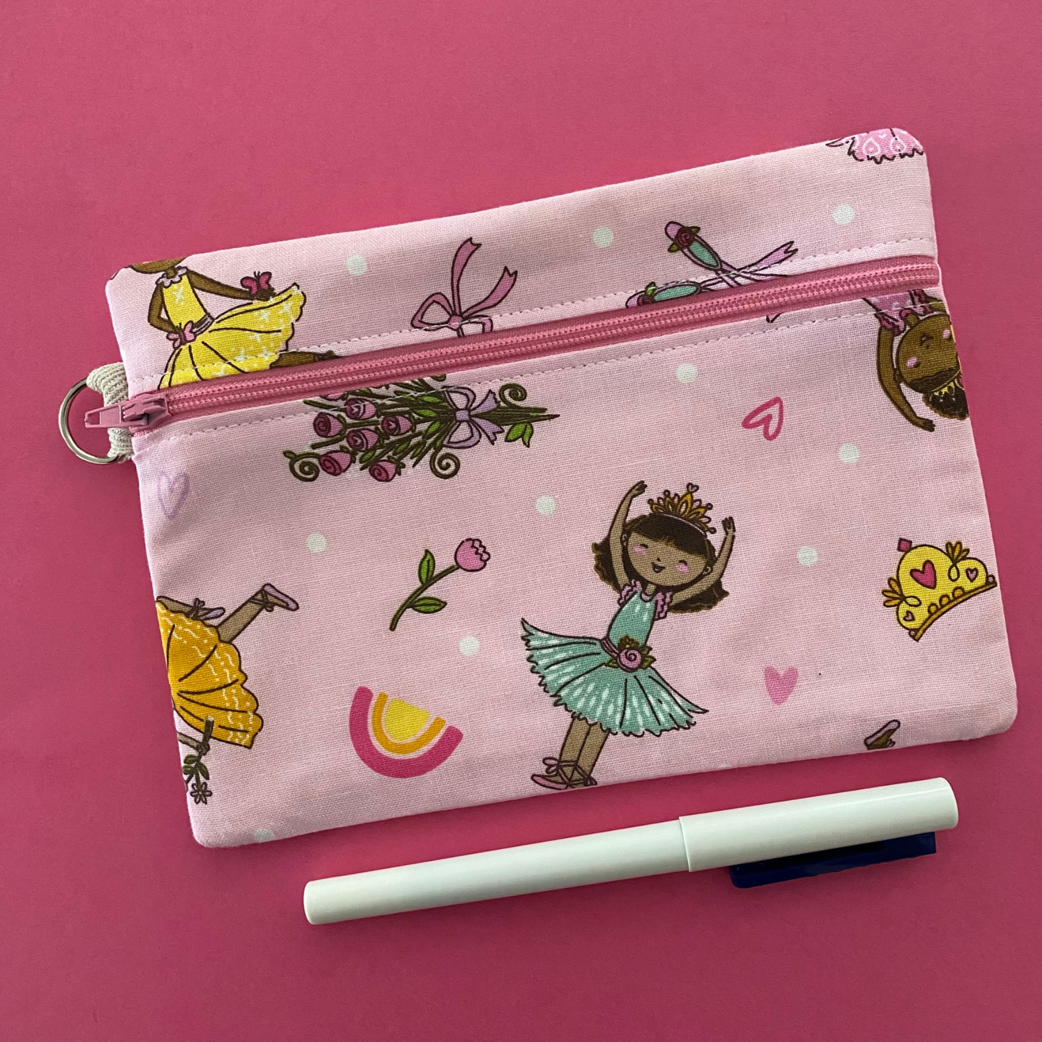 Ballet Girls zipper pouch, featuring endearing designs of ballerinas beautifully adorned with bouquets, flowers and hearts on a pink fabric.