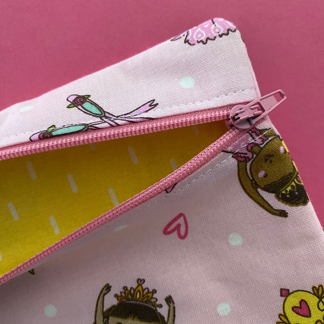 Ballet Girls zipper pouch, featuring endearing designs of ballerinas beautifully adorned with bouquets, flowers and hearts on a pink fabric with a lemon lining.