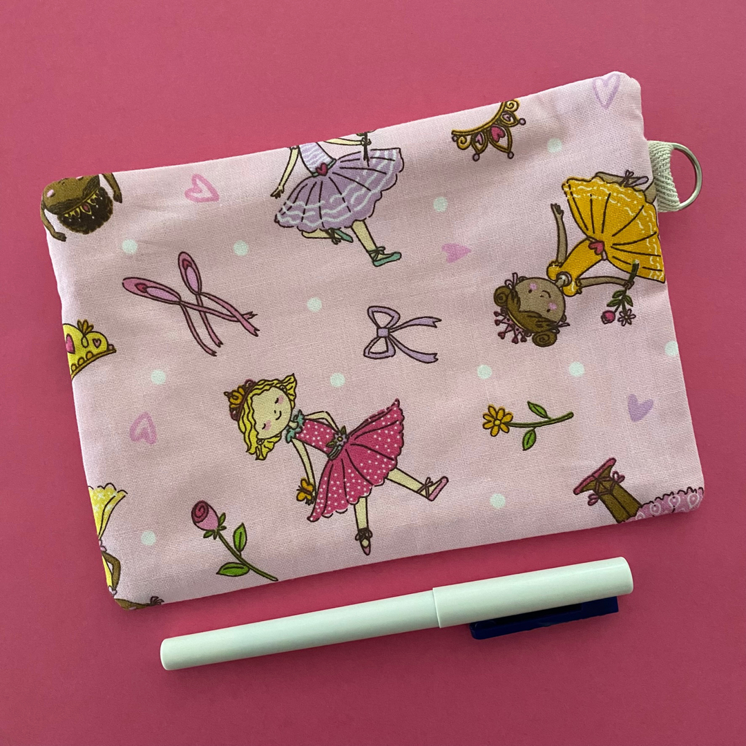 Reverse view of Ballet Girls zipper pouch, featuring endearing designs of ballerinas beautifully adorned with bouquets, flowers and hearts on a pink fabric.