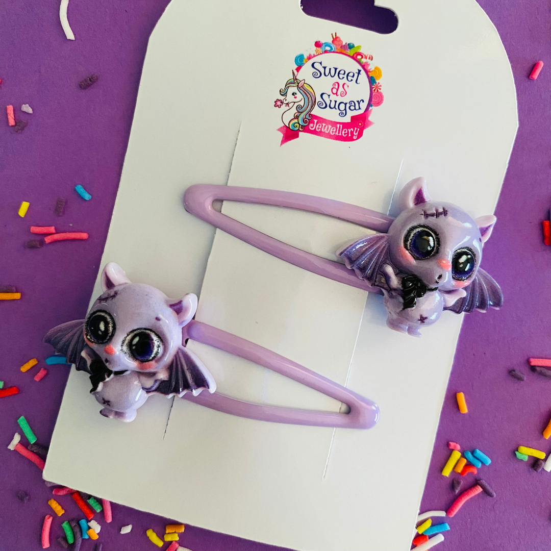 Pair of purple bats set on a lilac hair clip.