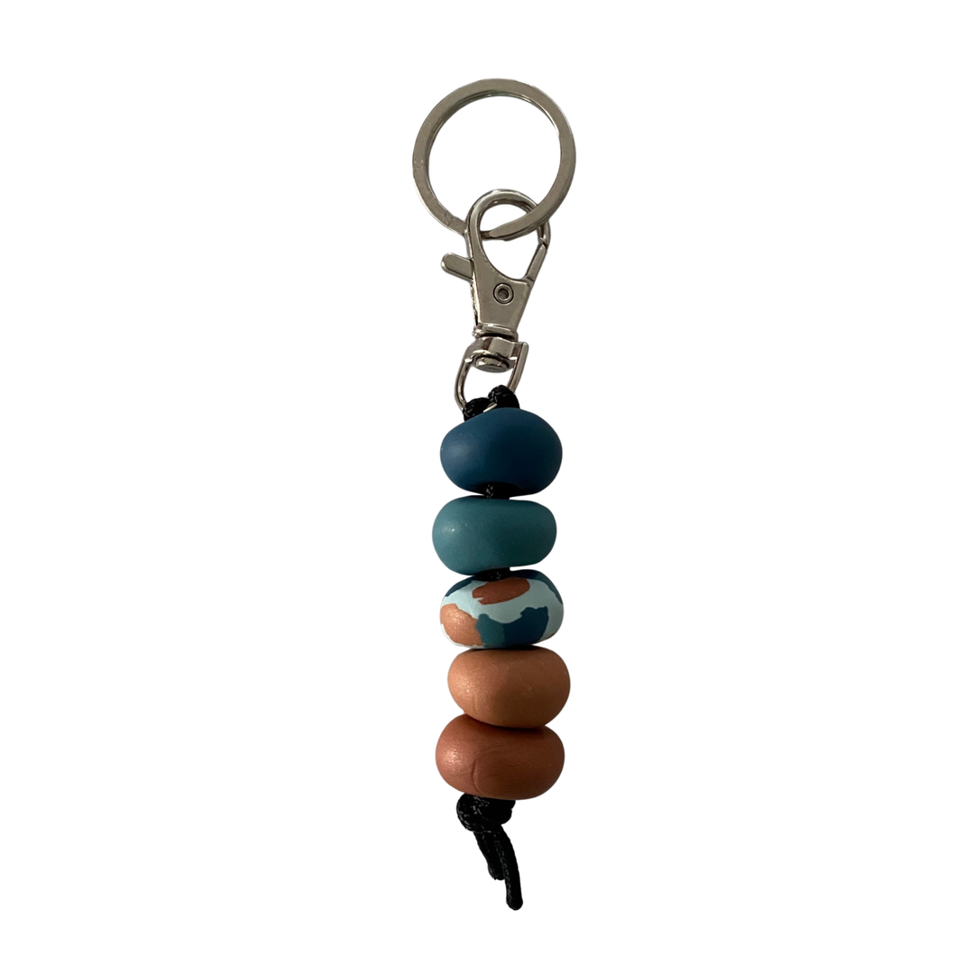 Handmade polymer clay keyring with five hand-rolled beads in stunning mix of sandy browns, ocean teals and marbled effects attached to a silver clasp and split ring.