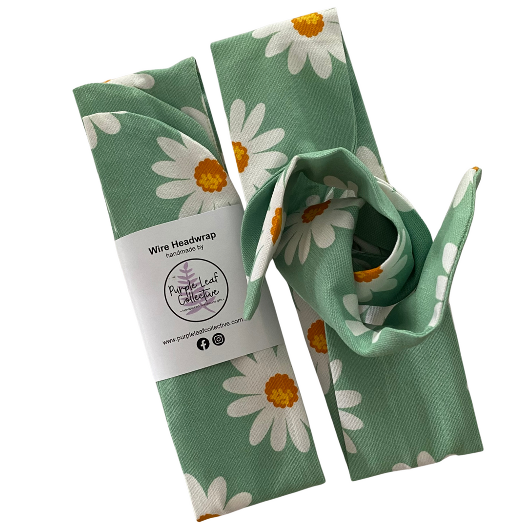 Green headwrap with white daisy pattern on a white background.