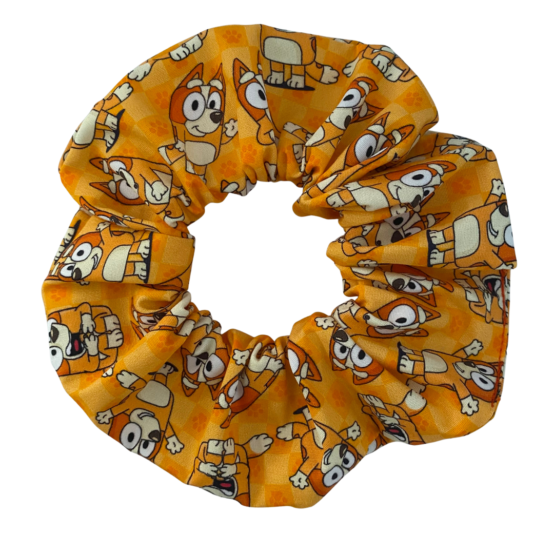 Handmade Bingo scrunchie featuring a repeating pattern of Bingo on a vibrant orange fabric.