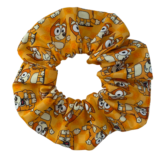Handmade Bingo scrunchie featuring a repeating pattern of Bingo on a vibrant orange fabric.