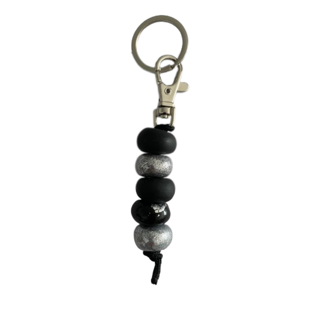 Handmade polymer clay keyring featuring five hand-rolled beads in a mix of black and silver glitter accents, attached to a silver clasp.