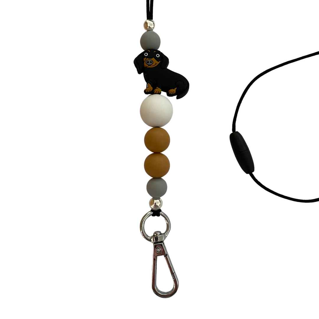 A 60cm black cord lanyard with breakaway clasp with a Black Sausage Dog silicone bead and other coloured silicone beads.