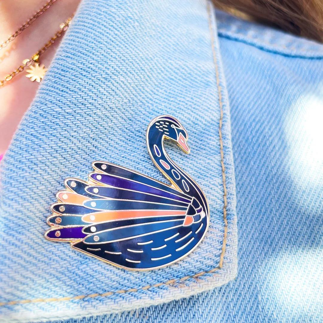 Black Swan enamel pin on a denim jacket.