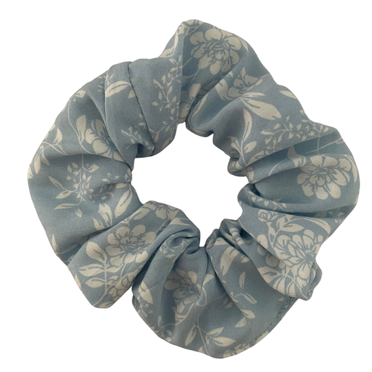 A blue rayon scrunchie featuring an elegant two-toned floral pattern in shades of blue and white.