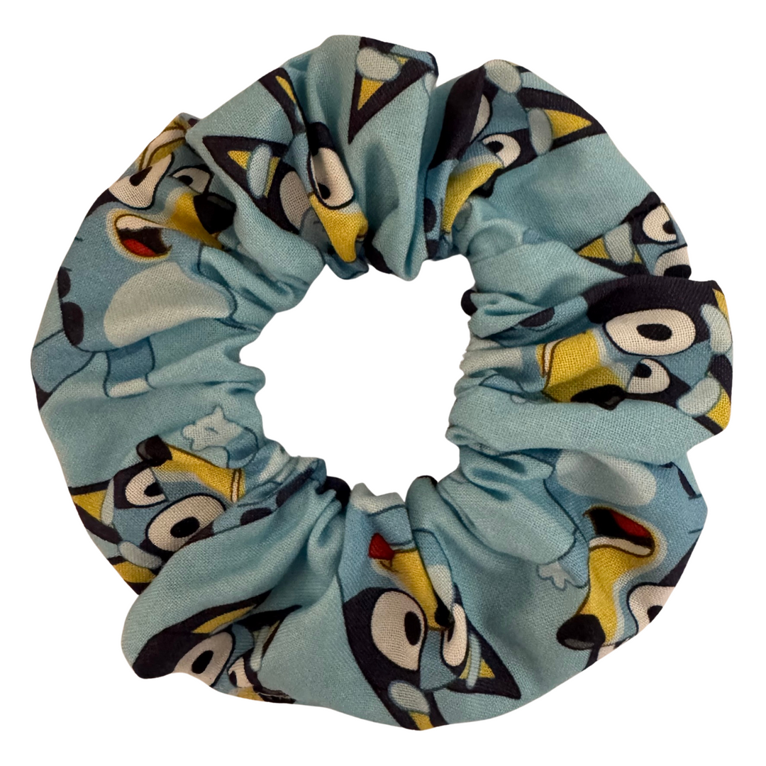 Bluey Scrunchie is handmade from soft cotton woven fabric featuring playful images of Bluey on a vibrant blue background.