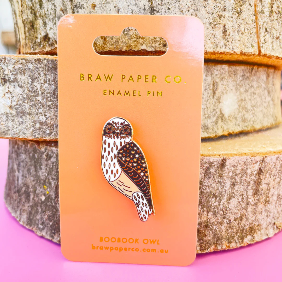 A picture of the Boobook Owl enamel pin on backing card.