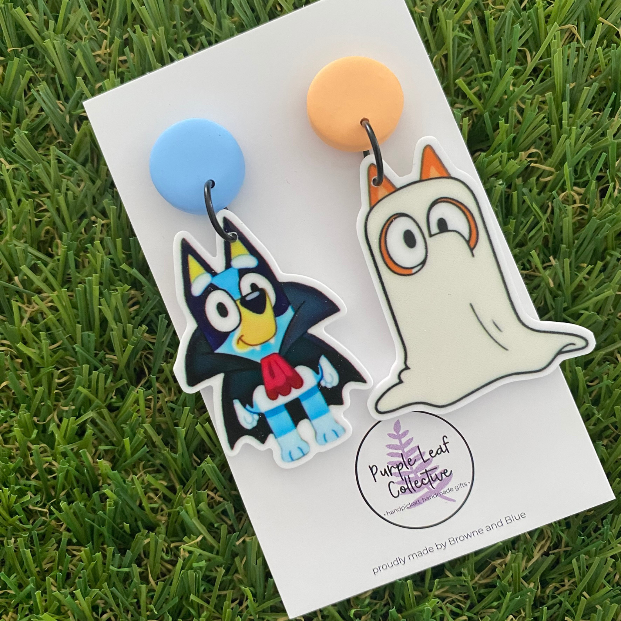 Booey dangle earrings featuring Dracula Bluey on a blue clay stud top and Ghost Bingo on an orange clay stud top.