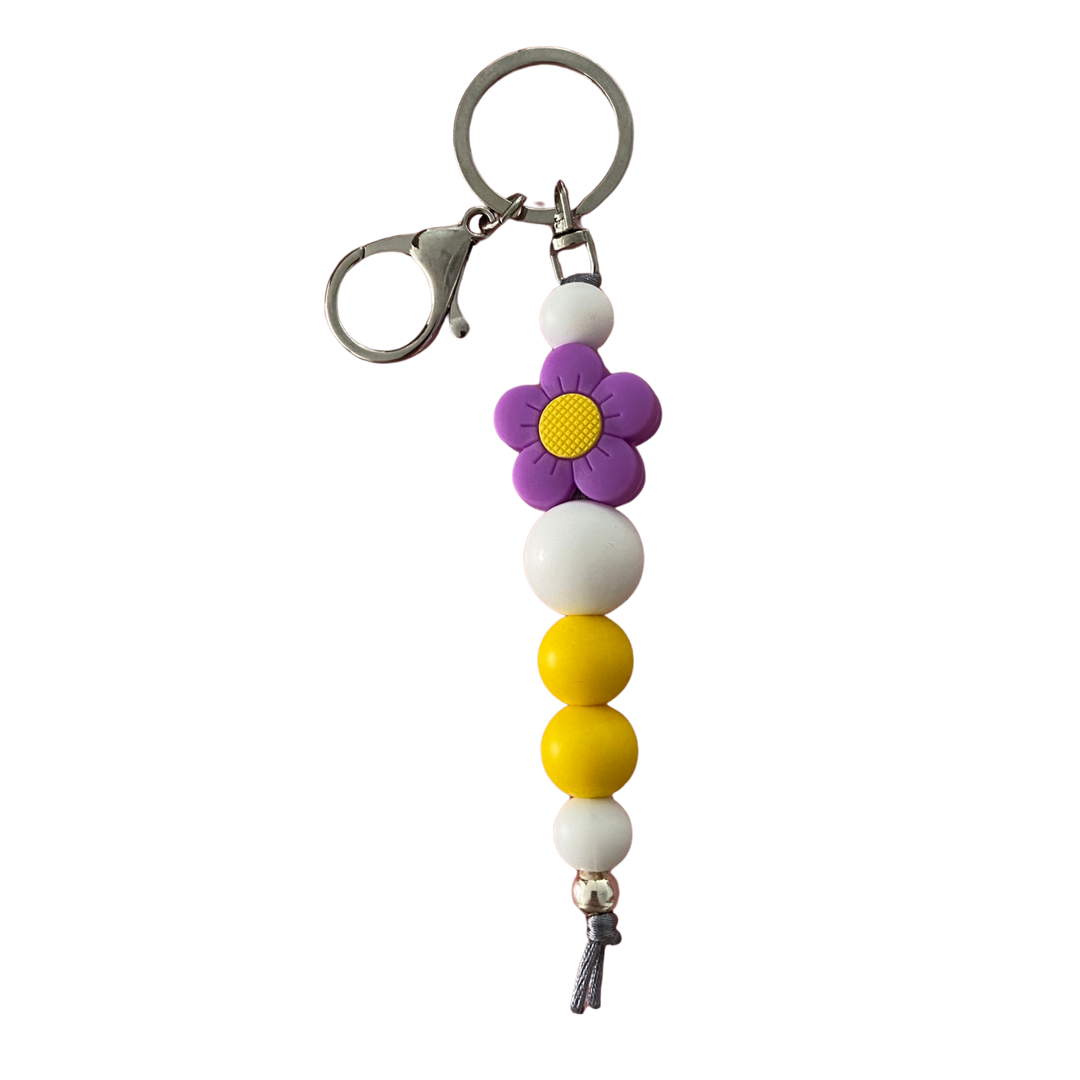 Bright Blooms Purple Flower silicone keyring with white and yellow beads, a 10mm aluminum bead, and durable nylon cord. Perfect for keys or bags.