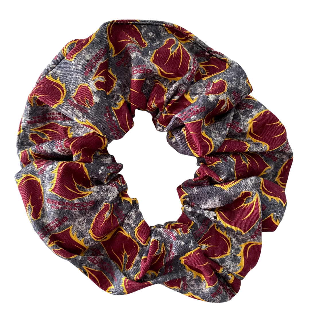 A scrunchie hair tie handmade with cotton woven fabric with images of the Brisbane Broncos rugby league team.