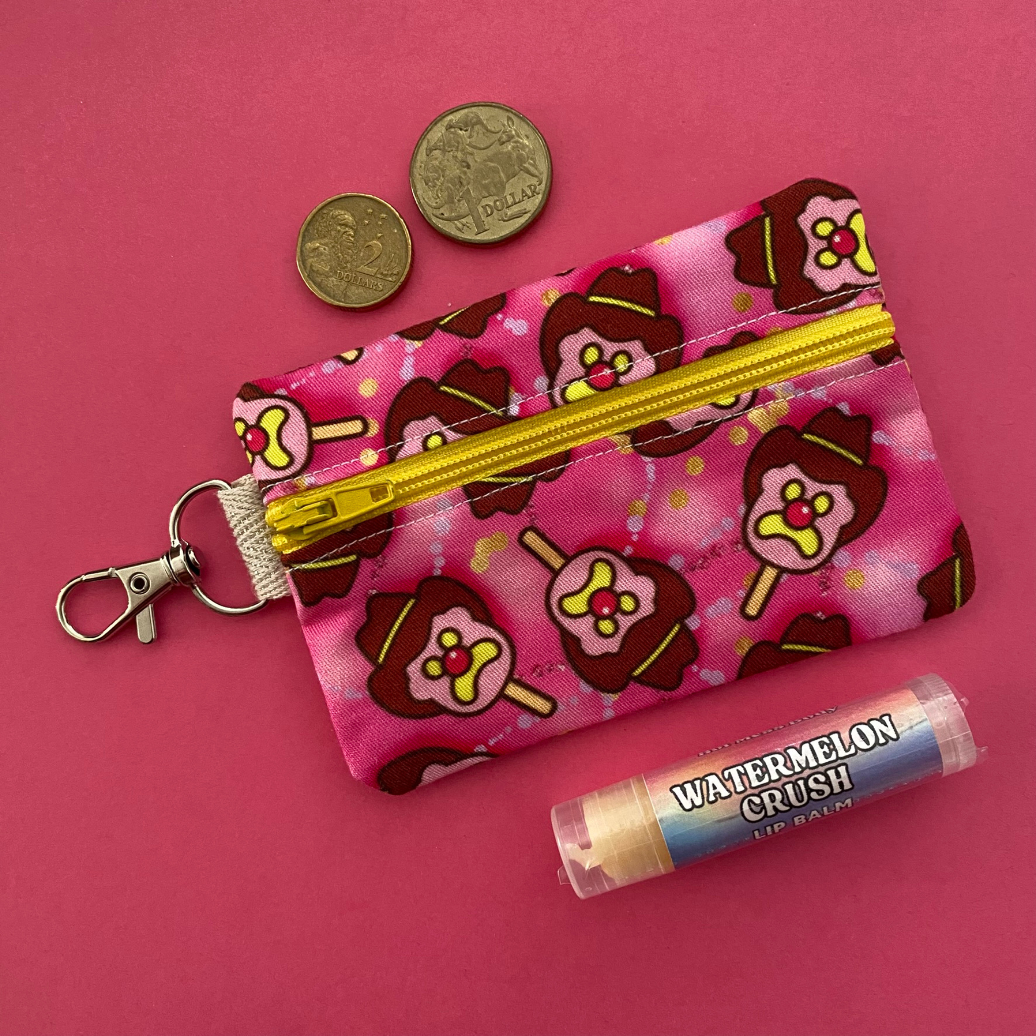 A clip coin purse with images of Bubble O'Bill on hot pink fabric.