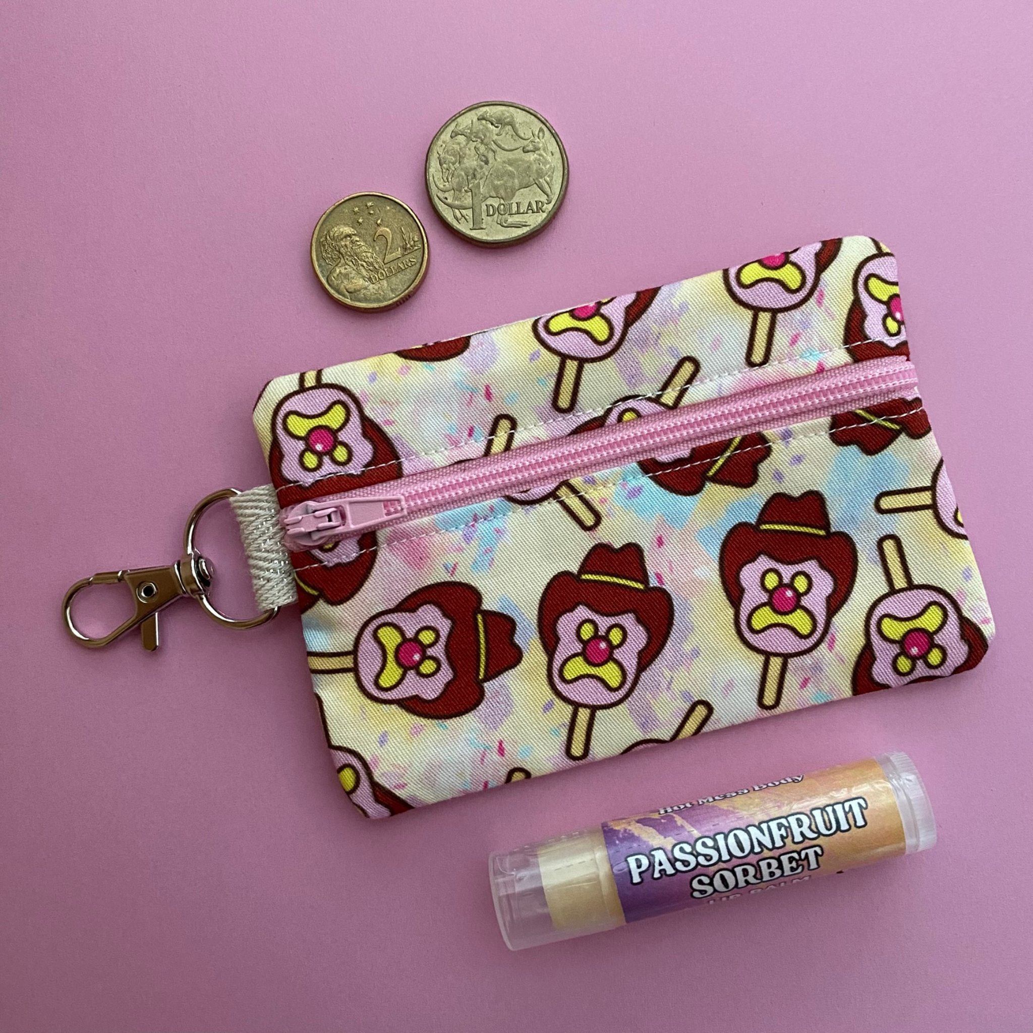 A clip coin purse with images of Bubble O'Bill on pastel yellow fabric.