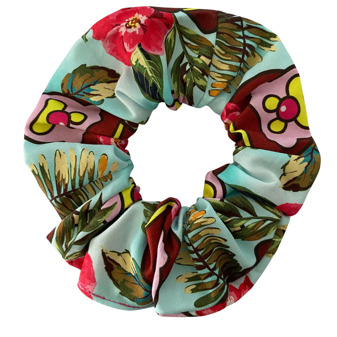 Floral and leaf patterned scrunchie on a white background.