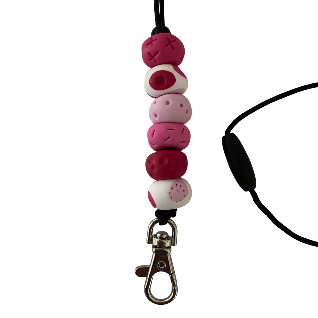 Handmade polymer clay lanyard with six hand-rolled beads in pink colours. Threaded on a nylon cord with a breakaway safety clasp and a silver-plated clip.