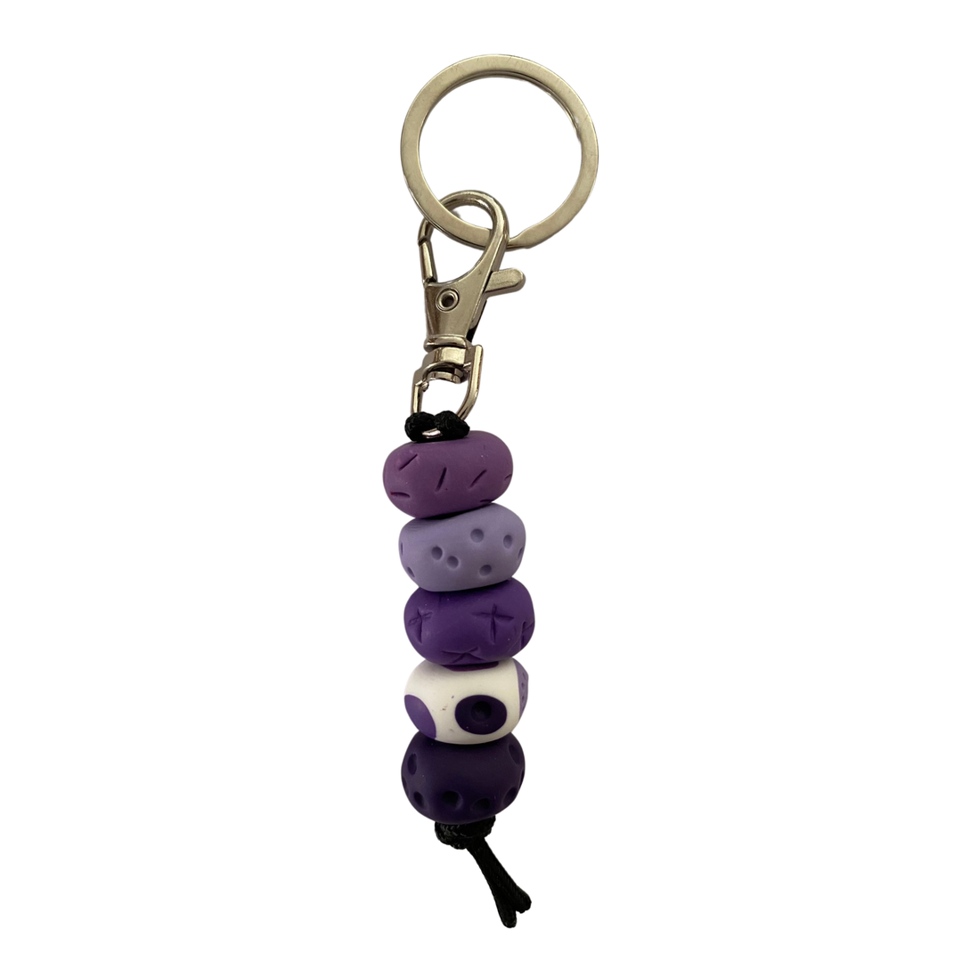 Handmade polymer clay keyring with five hand-rolled beads in purple colours attached to a silver clasp and split ring.