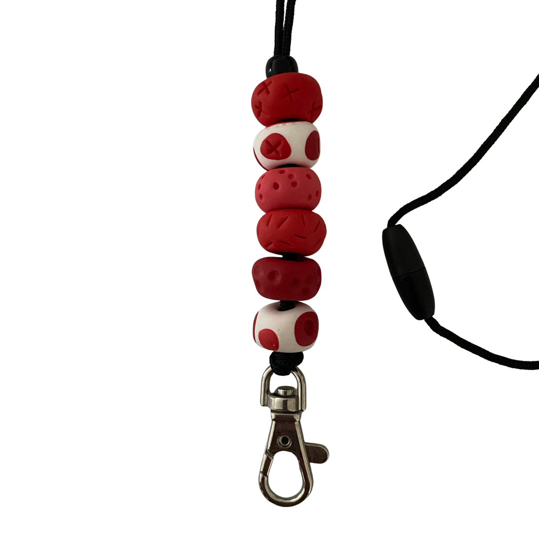 Handmade polymer clay lanyard with six hand-rolled beads in red colours. Threaded on a nylon cord with a breakaway safety clasp and a silver-plated clip.