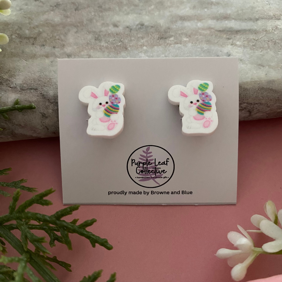 Clip-on earrings for non-pierced ears featuring a charming white bunny stacking three vibrant Easter eggs.