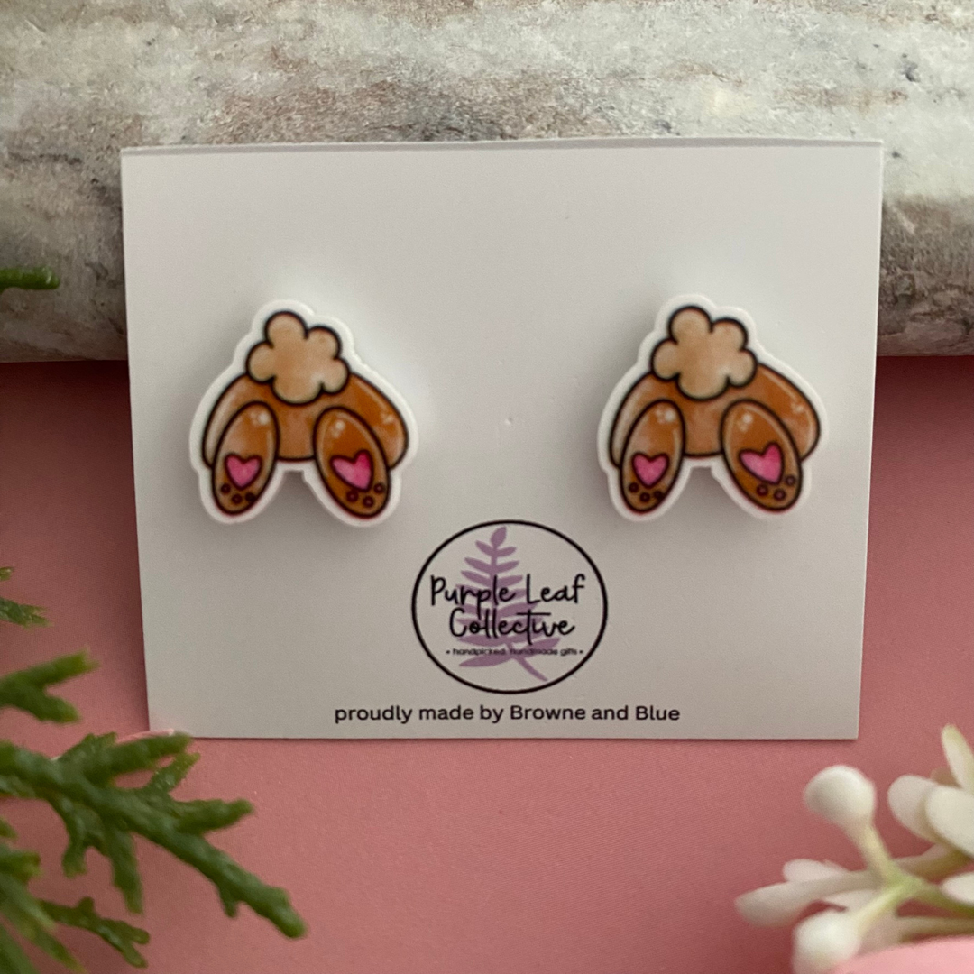 Rear view of a bunny earring featuring a cotton tail and two small pink bunny paws.