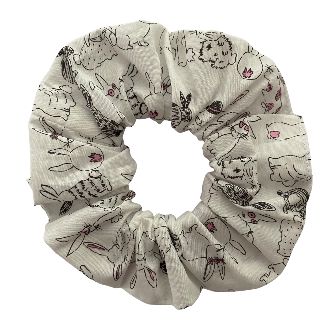 A scrunchie featuring adorable rabbit illustrations on crisp white fabric.