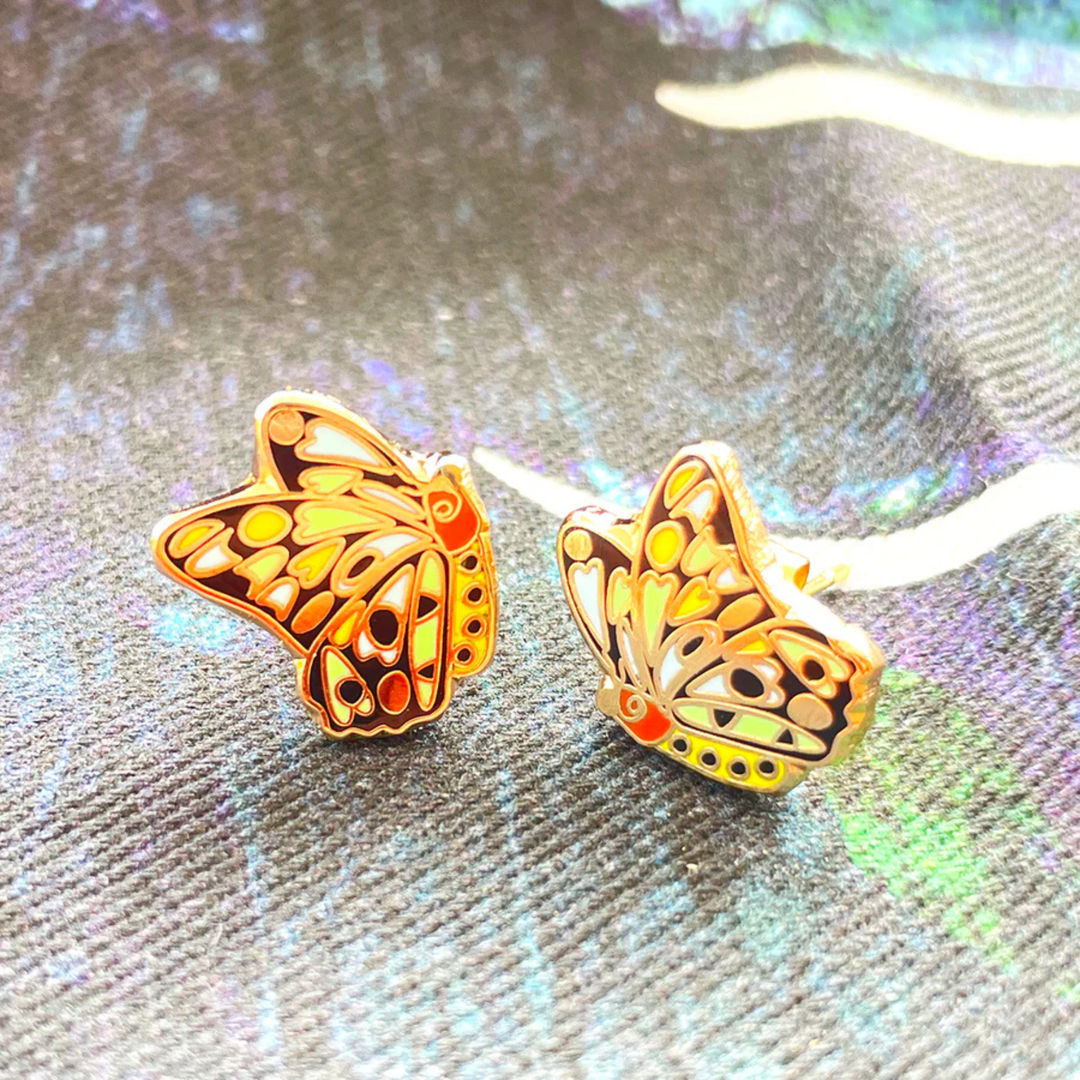 A close up view of a pair of Cairns Birdwing Butterly enamel stud earrings.