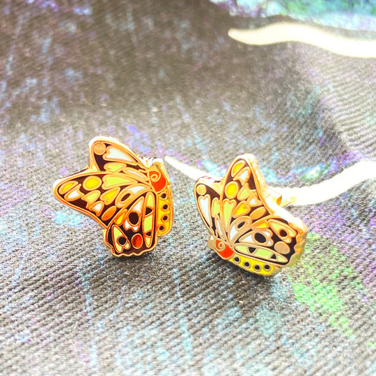 A close up view of a pair of Cairns Birdwing Butterly enamel stud earrings.